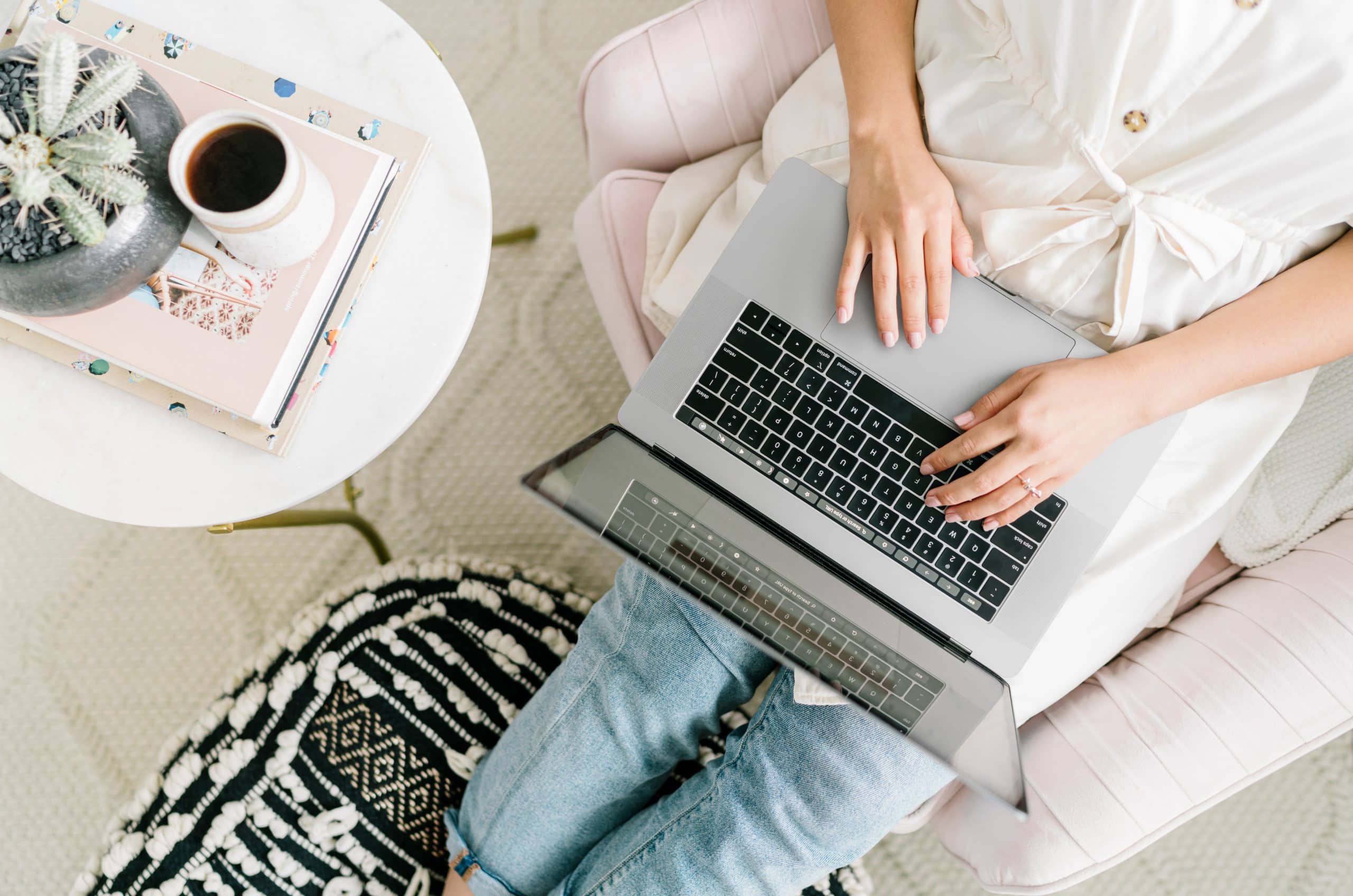 Overhead of a woman typing on a laptop on her lap